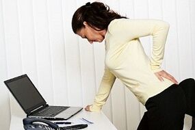 a woman has back pain in her lower back